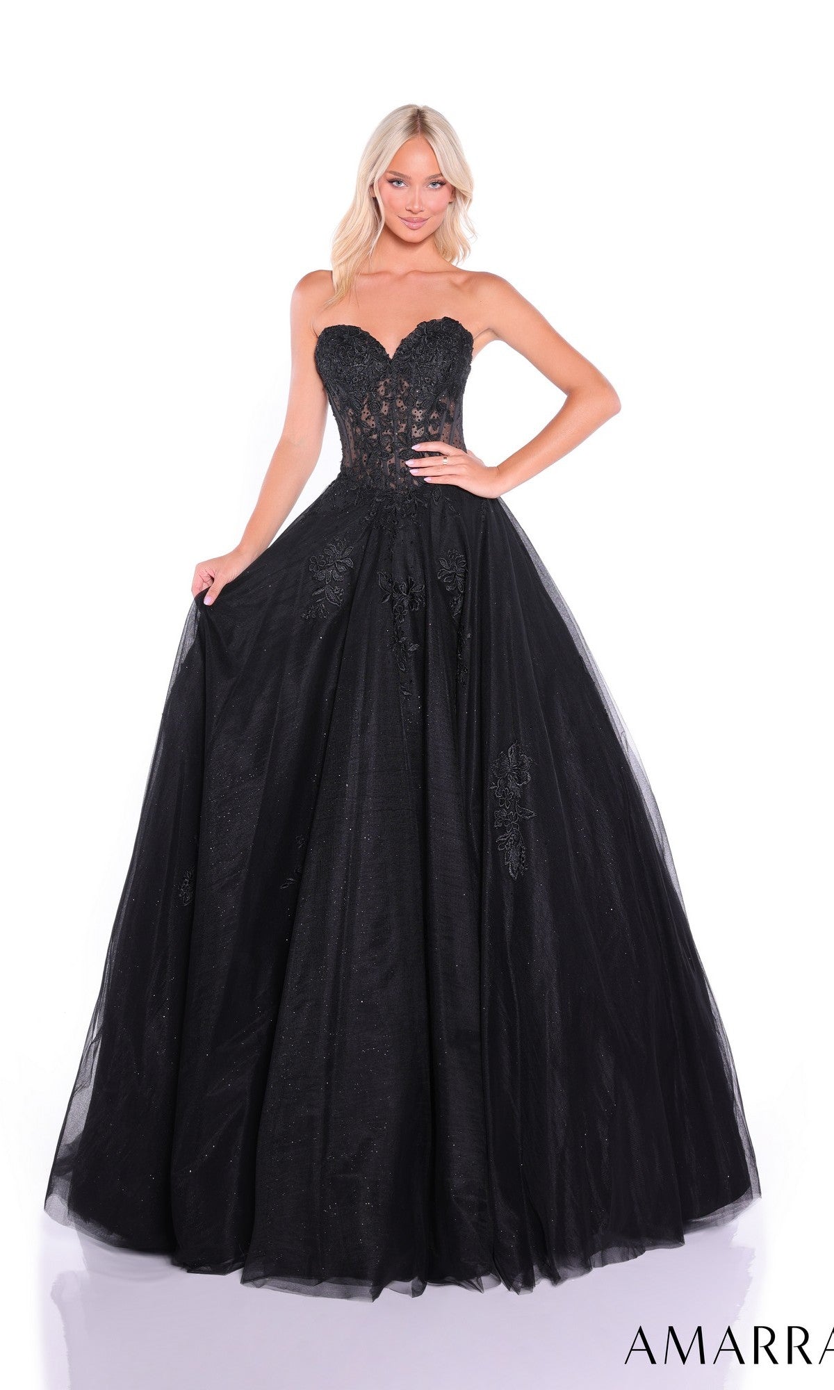 A woman wears the Amarra 89011 Lace-Up Strapless Prom Ball Gown with a sweetheart bodice, fitted lace detail, and a full tulle skirt, standing against a white background.